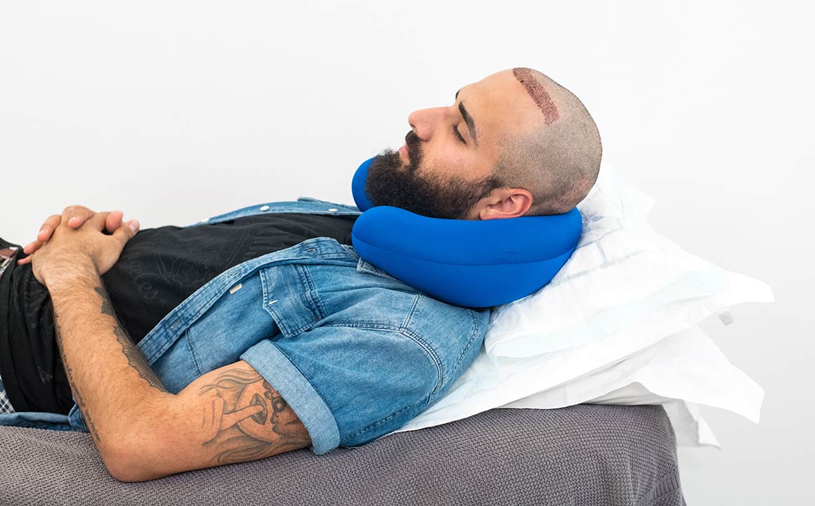 Man sleeps with neck pillow